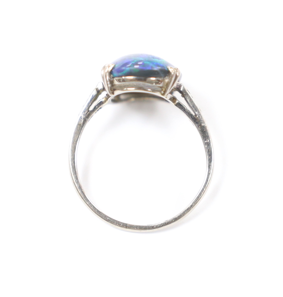 An 18ct, plat and single stone cabochon black opal set ring, with six stone diamond chip set shoulders, size K, gross weight 2.6 grams.